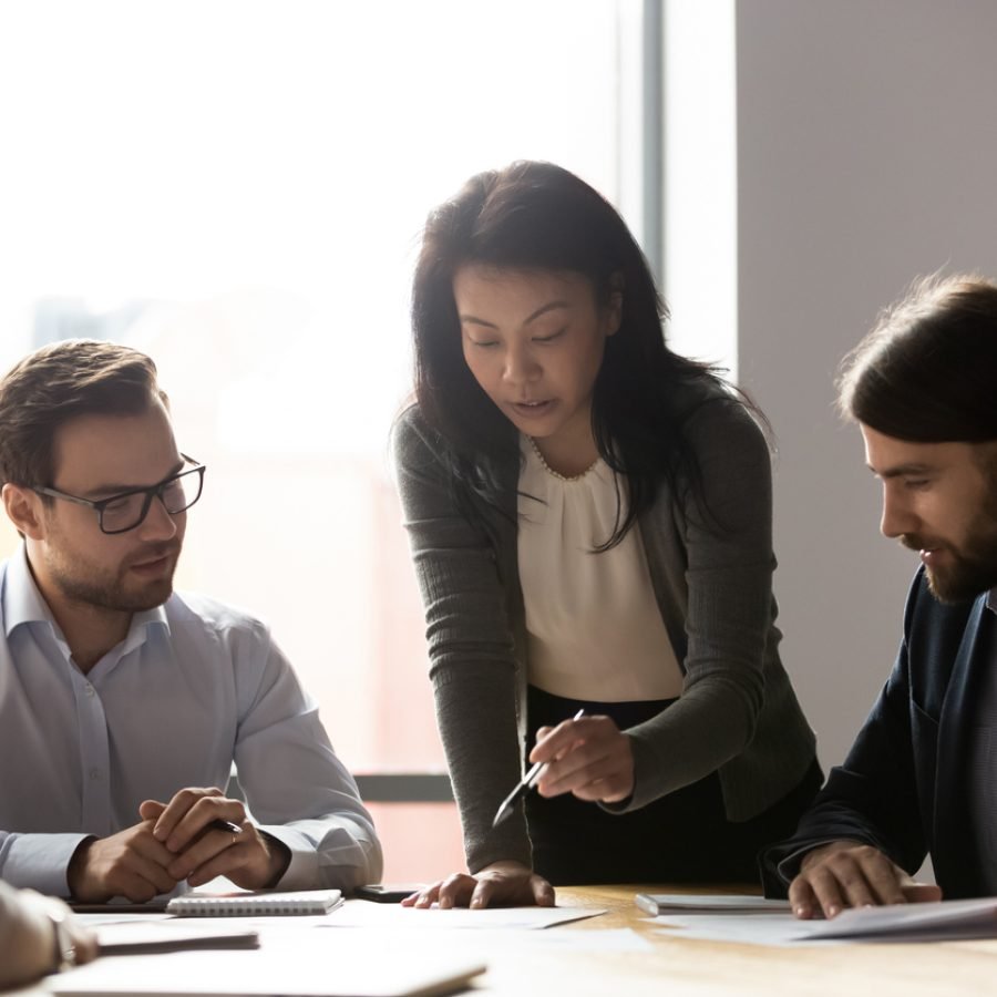 older asian busineswoman sharing project ideas to workers.